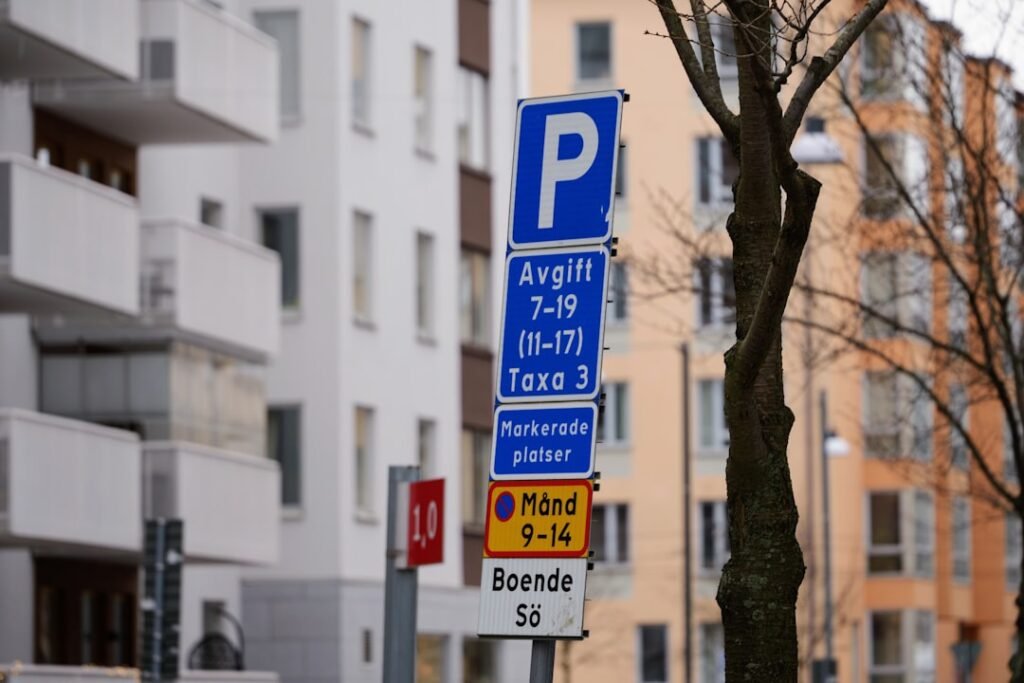 a blue parking sign sitting on the side of a road